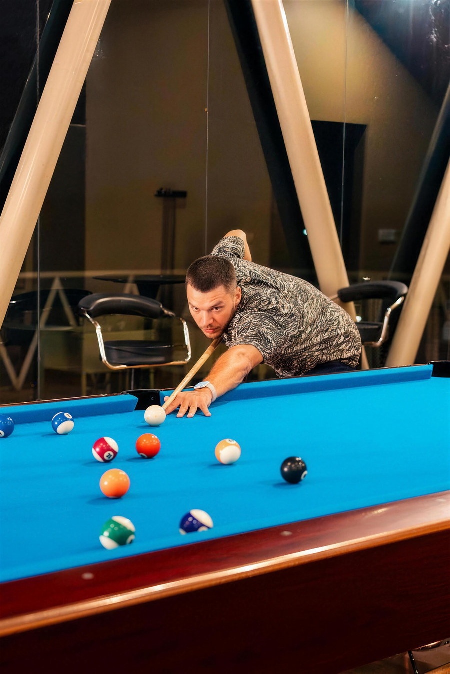 A guest playing billiards at The Glow