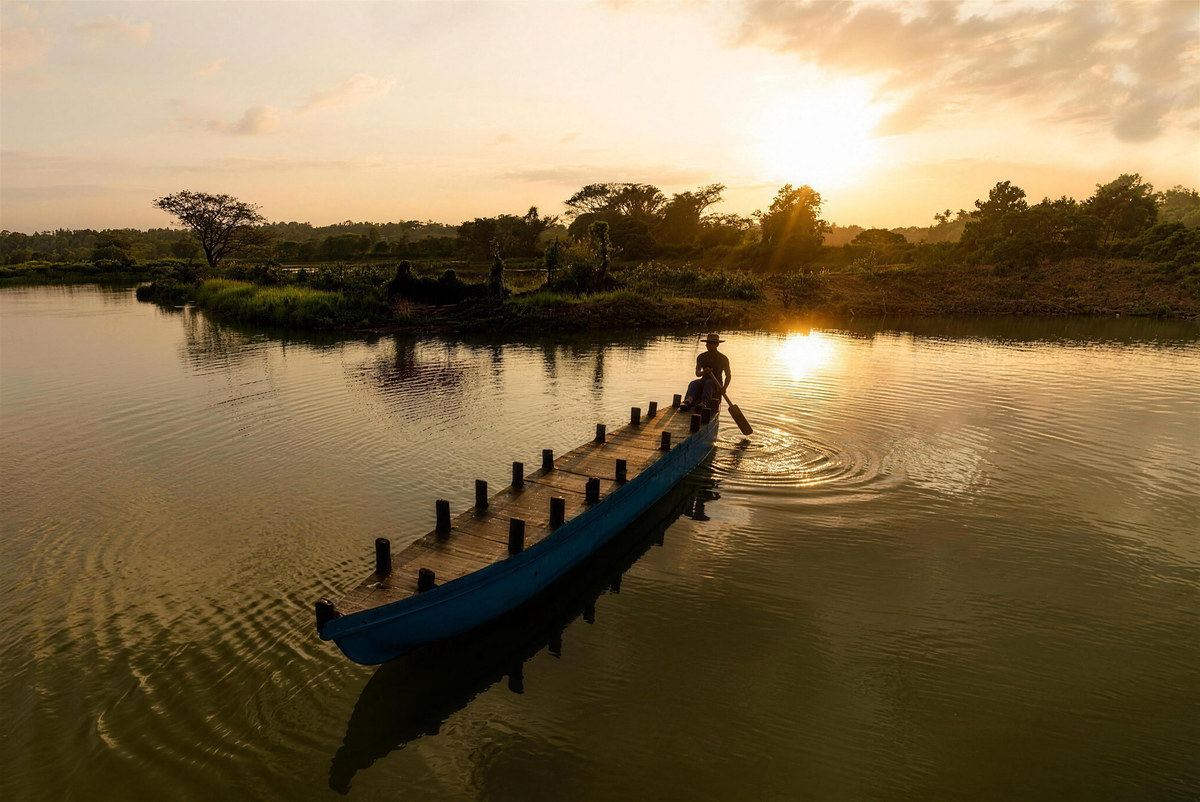 A boatman crossing the lake at sunset