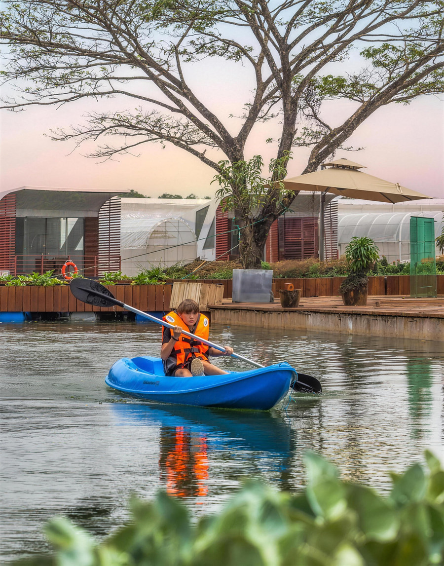 A guest kayaks past the floating cabanas on the lake