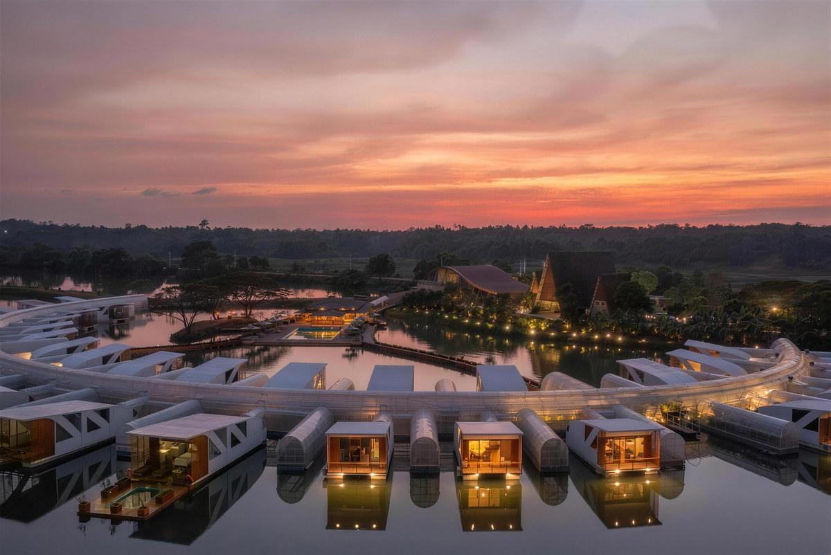 Floating cabanas lit at dusk under a red sky