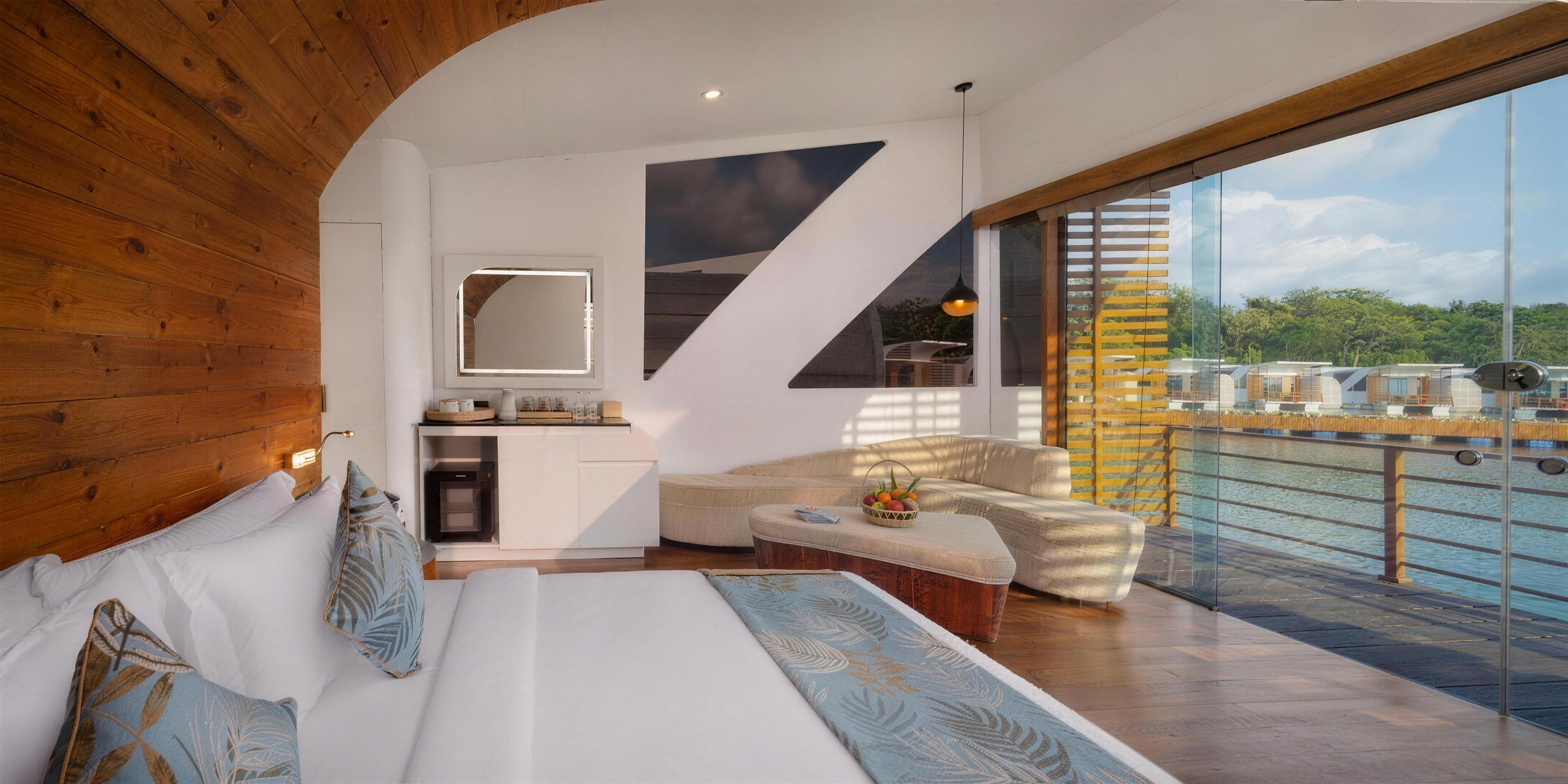The Bolagala Royal Suite with a king bed, lounge and panoramic windows onto the lake