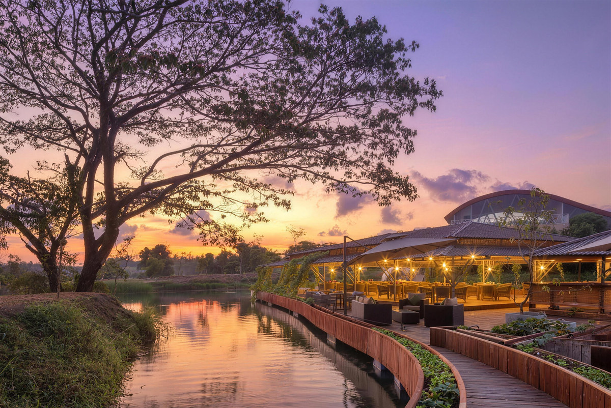 The Float restaurant and the lakeside walkway at sunset, reflected in still water